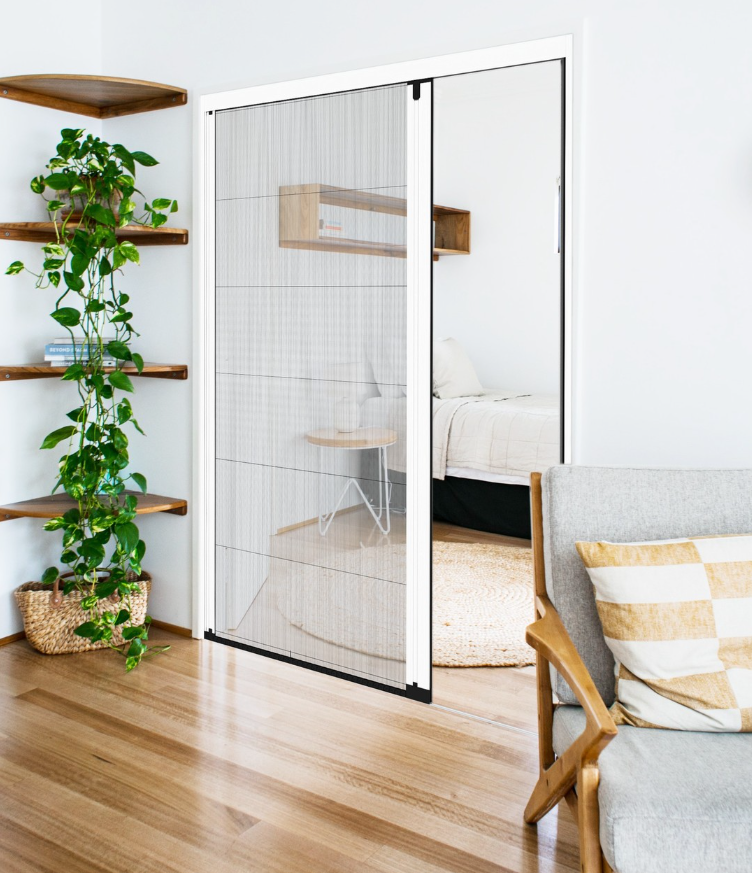 White pleated mesh screen door in an interior doorway, partially open toward a bedroom